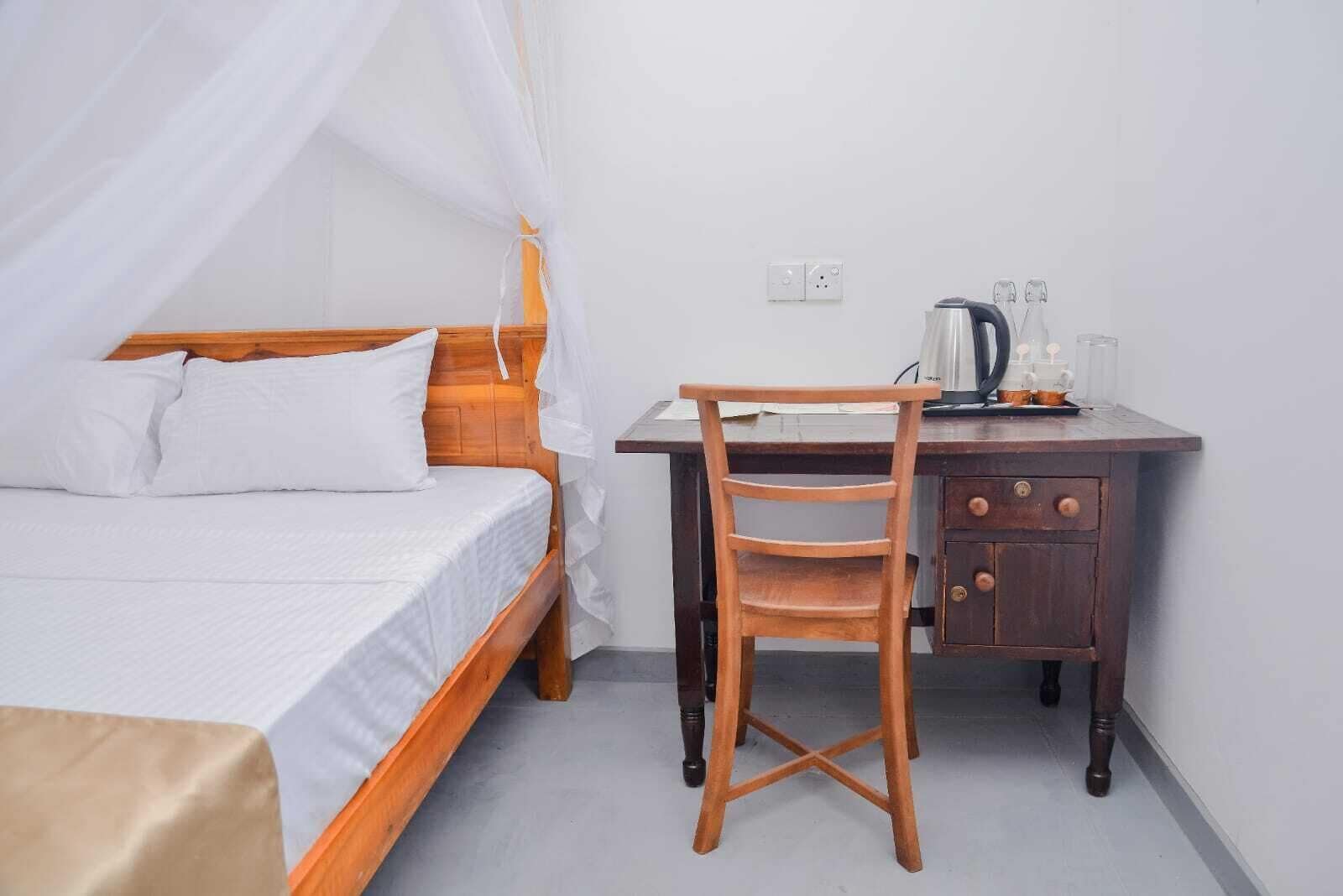 A room with a bed, a wooden desk, and a chair.