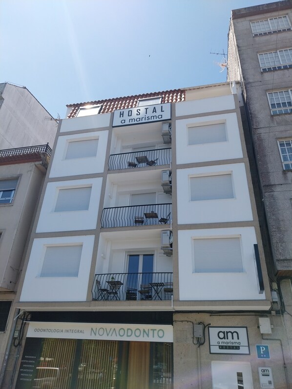 A building with a sign reading "HOSTAL a marisma" and another sign for "NOVAODONTO". - A Marisma Hostal (Redondela)
