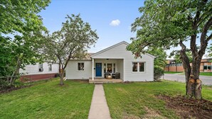 A single-story house with a front porch, a blue door, and a small front yard.
