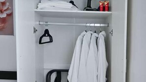 A walk-in closet with hanging space, shelves, and a drying rack. - Wythenshawe Greenbrow Retreat (Manchester)