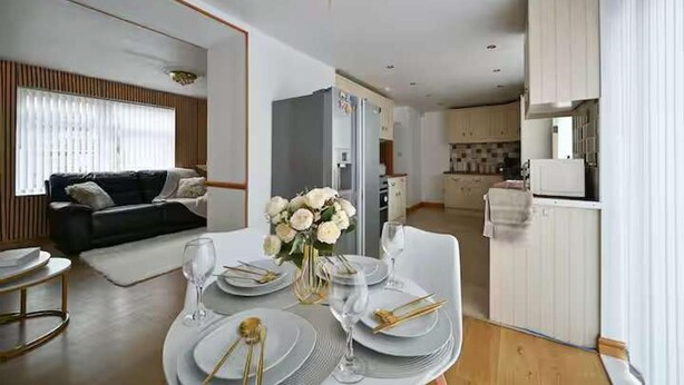 A modern living room with a dining area set for a meal. - Wythenshawe Greenbrow Retreat (Manchester)