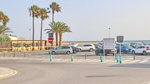 A parking lot with cars, a no entry sign, and a sign indicating only small cars are allowed.