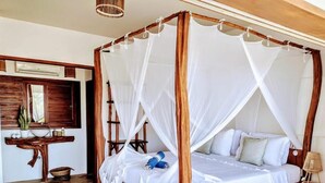 A four-poster bed with a canopy, a wooden bedside table, a lamp, and a small plant on the nightstand. - Villa Pinolo (Cruz)