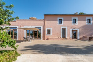 Un bâtiment doté d’un patio, d’un espace extérieur aménagé pour s’asseoir et d’une entrée couverte.