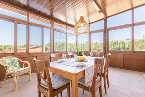 Un comedor con una mesa de madera, sillas y una lámpara colgante.