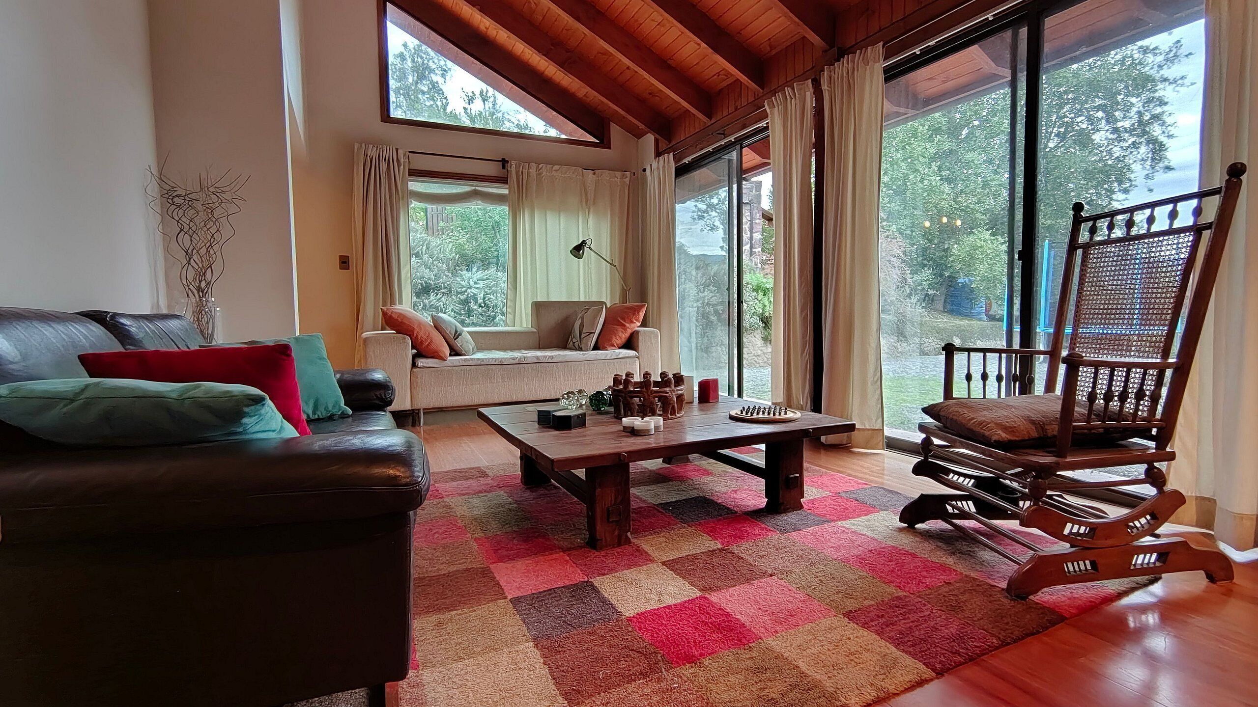 A cozy living room with a sofa, a wooden coffee table, and a rocking chair.
