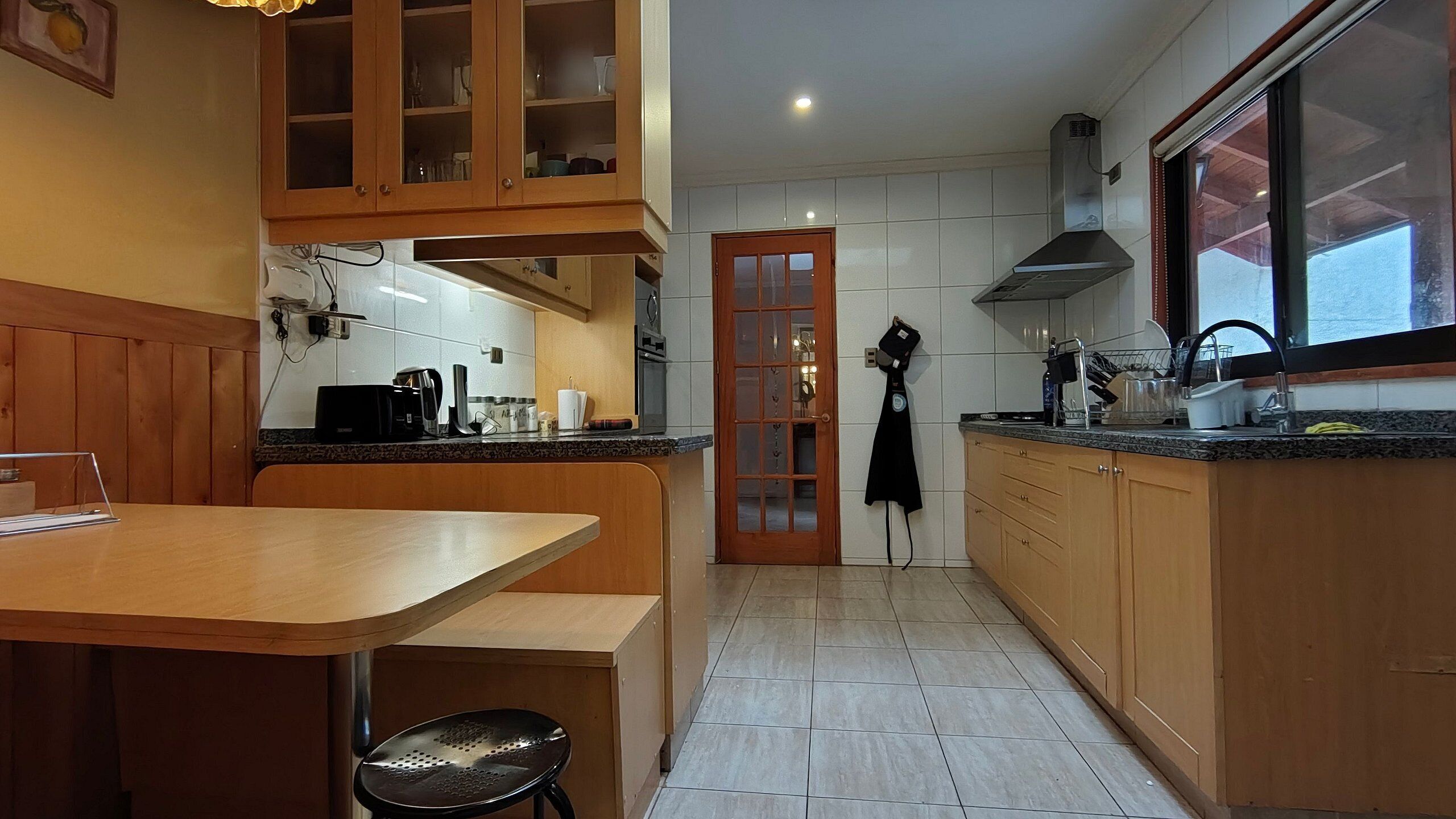 Una cocina con armarios de madera, una encimera, un lavabo y una estufa.