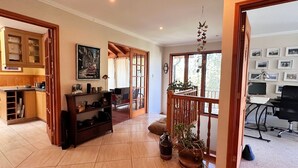 A spacious living area with a kitchen, a dining area, and a balcony with potted plants. - Oceana Suites - Laguna Aculeo (Paine)