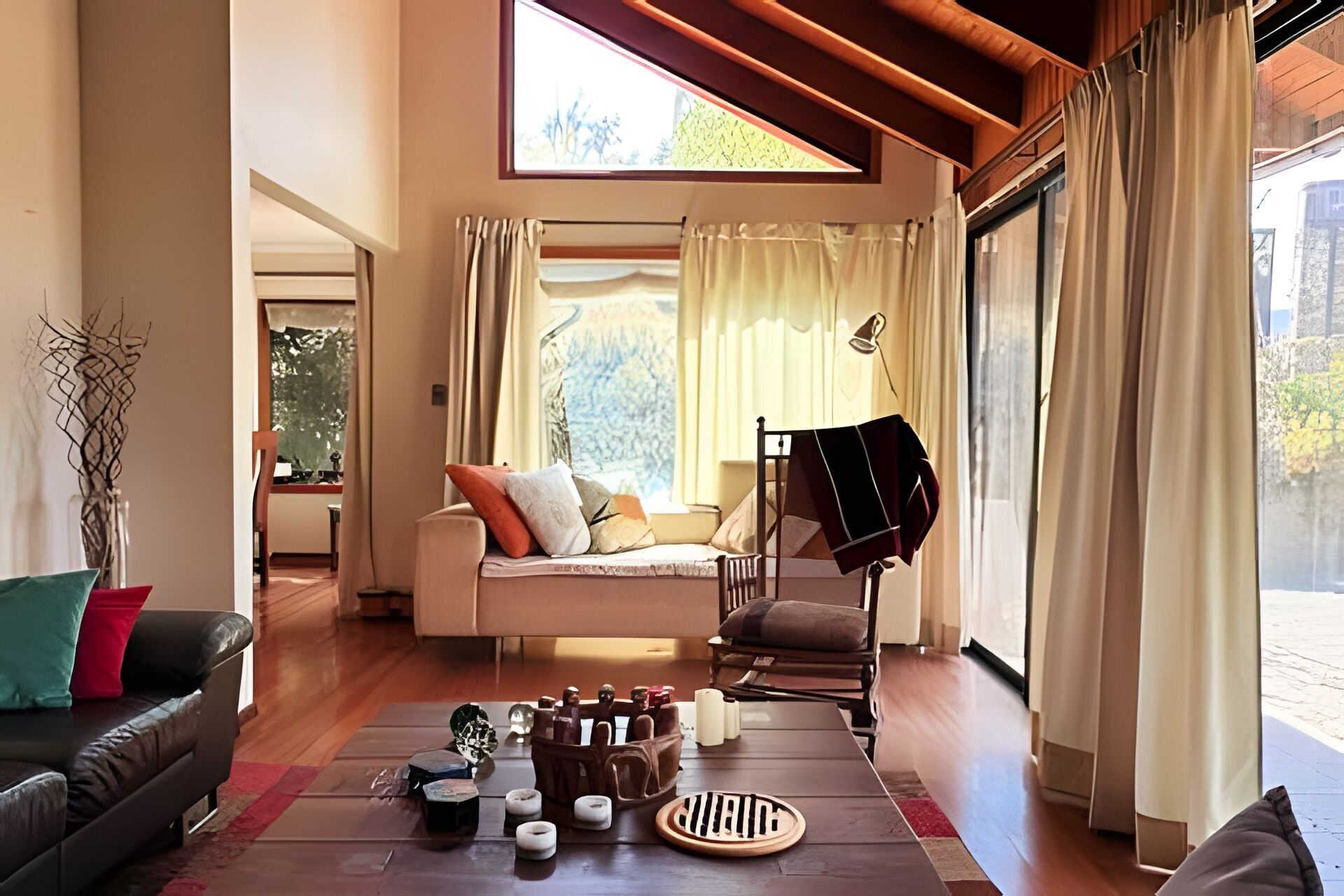 A cozy living room with a sofa, a chair, a coffee table, and a piano.