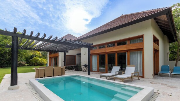 A modern house with a swimming pool, outdoor seating, and a pergola. - Green Village 2BDR villa w/ pool (La Altagracia)