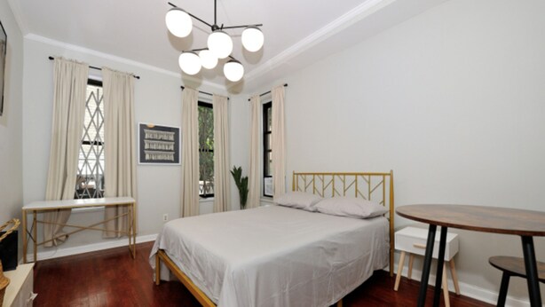 Une chambre à coucher avec un lit, un bureau, une chaise et une table.