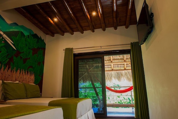 Una habitación con una cama, un ventanal con vistas a la vegetación y un techo de madera.