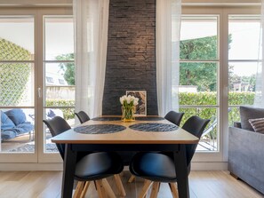 A dining area with a stone accent wall, a table with placemats, and chairs. - Le Mangin Privé (Metz)