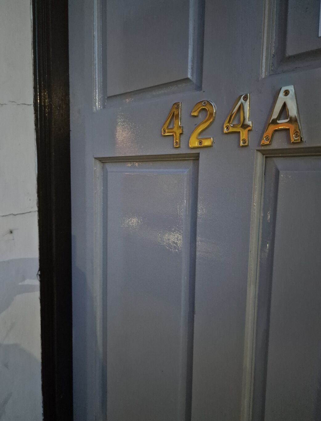 Uma porta com o número 424A em letras douradas.