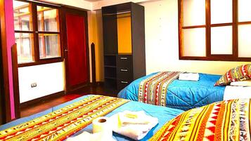 Habitación de hotel con dos camas, un armario y una ventana.