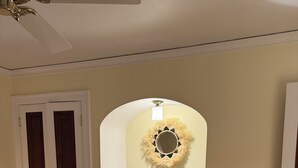 Une chambre à coucher comprenant un lit, une coiffeuse avec un miroir, une porte et un objet décoratif fixé au mur.