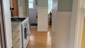 Une cuisine équipée d’une cuisinière, d’un four et de meubles de rangement en bois.