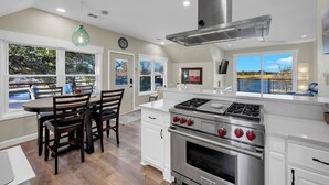 A modern kitchen with a large island, stainless steel appliances, and a view of a lake. - Lakeside Lounge on Lake LBJ! (Llano County)