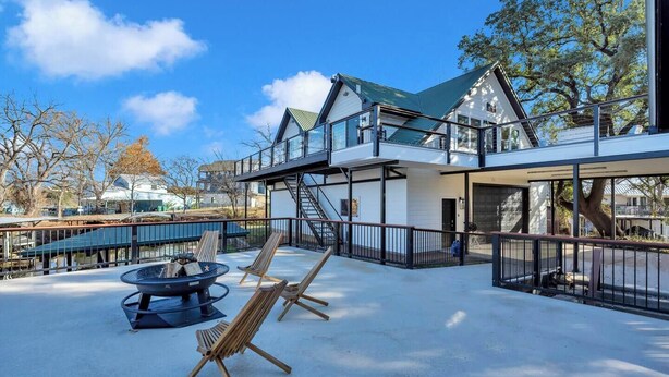 A modern building with a glass balcony, outdoor seating, and a fire pit. - Lakeside Lounge on Lake LBJ! (Llano County)