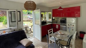 Un espace de vie compact comprenant un coin repas, une kitchenette et un canapé.