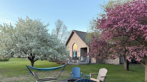A patio area with a hammock, Adirondack chairs, and a fire pit. - The Fairway Escape – Spacious 6BR Golf Course Retreat, Walk to Downtown Hayward! (Hayward)