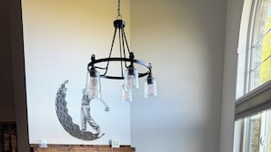 A dining area with a wooden table and chairs, a fireplace, and a chandelier. - The Fairway Escape – Spacious 6BR Golf Course Retreat, Walk to Downtown Hayward! (Hayward)