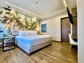 Una camera da letto moderna con un letto grande, un comodino, una TV a parete e una porta.