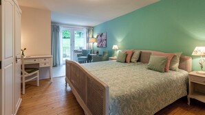 A bedroom with a bed, bedside tables, a desk, and a chair.