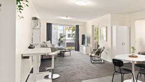 Una sala de estar moderna con sofá, mesa de centro y un comedor con mesa y sillas.