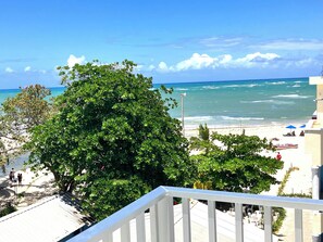 Un balcon avec vue sur une plage et l’océan.