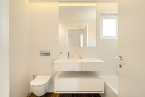 A modern bathroom with a toilet, a sink, and a bathtub. - Cascais Garden Escape by Cadenzalux (Cascais)