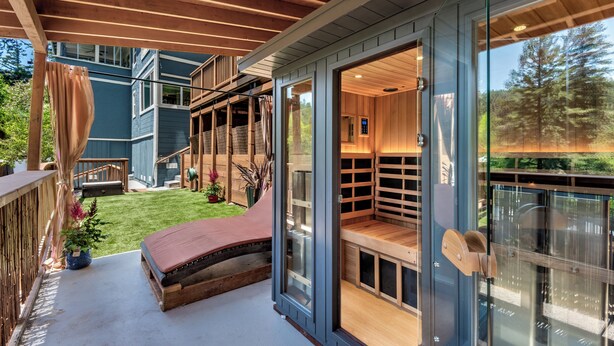 A modern house with a glass door leading to a wooden deck and a built-in sauna. - Redwood Retreat  Sauna, Plunge, Jacuzzi & Views (Camp Meeker)