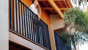 Un balcón con barandas de madera y vista al interior del edificio.