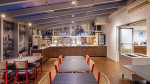 A restaurant with a long counter, multiple seating options, and a variety of food and drink stations. - Walk to Times Square + Free Breakfast & Wi-Fi (New York)