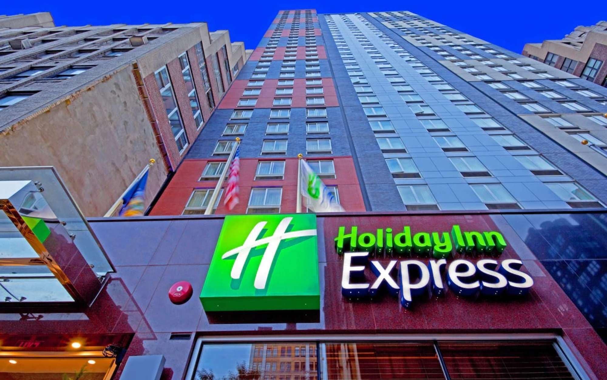 A Holiday Inn Express building with a prominent green logo and a red facade.