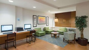 A modern hotel lobby with a reception desk, computers, green seating area, and a large window with blinds. - Close to Times Square + Free Breakfast & Wi-Fi (New York)