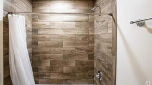 A shower area with wooden panel walls and a metal shower rod.