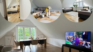 Un salon moderne avec un téléviseur, des sièges et un coin repas.