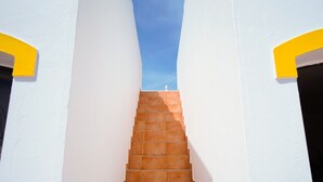 Una escalera que conduce a un edificio blanco con detalles amarillos.