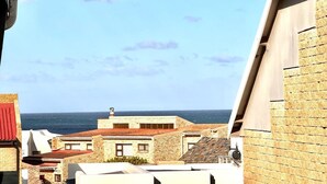A coastal building with a view of the sea. - Newly renovated, charming studio in central Jeffreys Bay with AC, WiFi, parking (Jeffreys Bay)