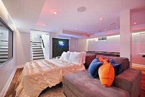 Une chambre moderne avec un lit, un canapé et un escalier.