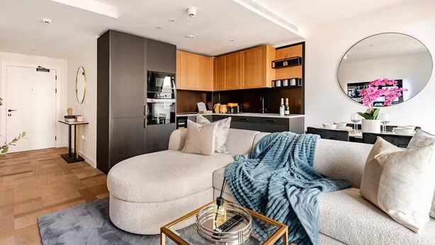 A modern living room with a sofa, coffee table, and kitchen in the background. - Chic 2 Bed Apartment with AC, WiFi by London's Tower Bridge (London)
