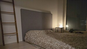 A bedroom with a bed, a ladder, a nightstand, a lamp, and a window with blinds. - Helsinki City or Airport 16min, Convenience Place (Vantaa)