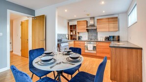 A modern kitchen with wooden cabinets, a central island, and built-in appliances. - City Retreat in Manchester (Manchester)