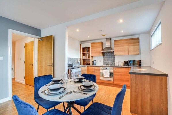 A modern kitchen with wooden cabinets, a central island, and built-in appliances. - City Retreat in Manchester (Manchester)