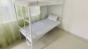 Ένα δίκλινο κρεβάτι σε ένα δωμάτιο με παράθυρο και λεπτά, διάφανα κουρτίνες.
