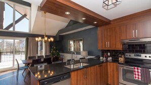 A modern kitchen with wooden cabinets, a black countertop, a dishwasher, and a stainless steel oven.