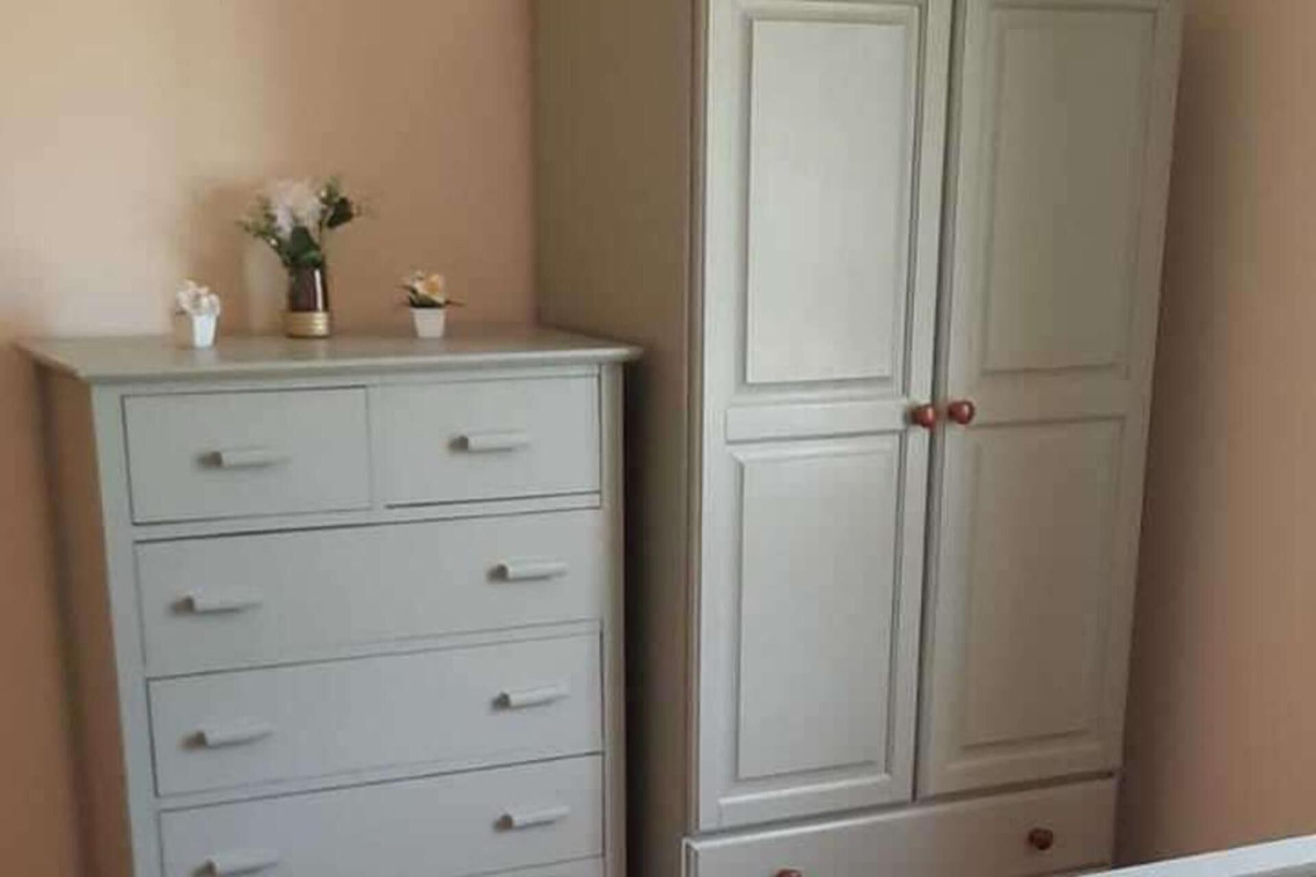 A white dresser with drawers and a cabinet with two doors.