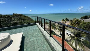 A balcony with a view of the ocean and palm trees. - Get Sense Beira Mar (Joao Pessoa)