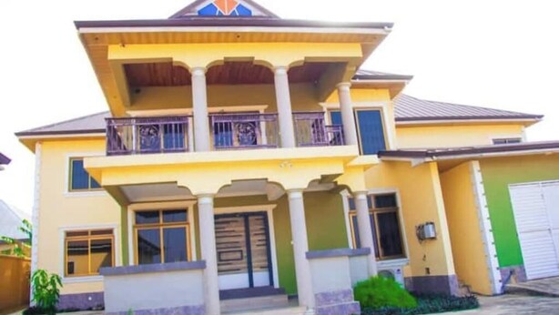 A two-story house with a balcony, a front porch, and a garage. - Salma's Place (Kumasi)